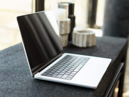 Modern laptop showing blank screen sitting on desk in home office
